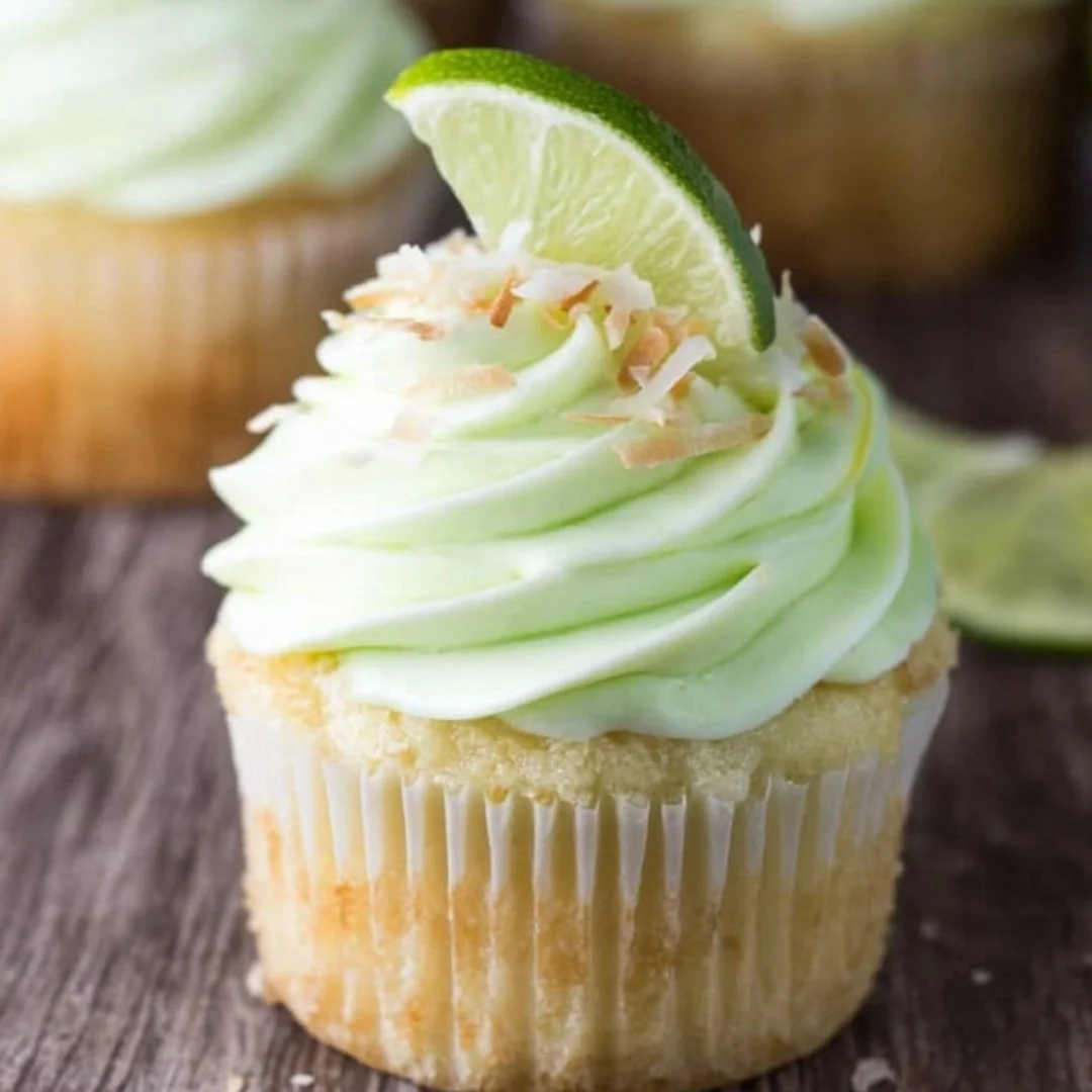 Delicious coconut cupcakes topped with lime frosting on a decorative plate