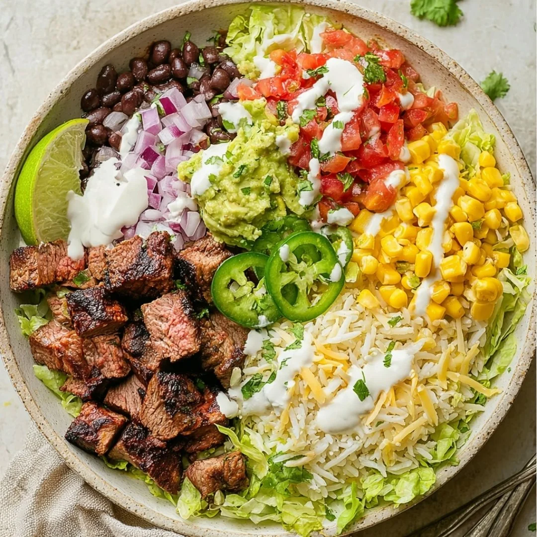 Steak burrito bowls with rice, beans, and toppings in a bowl