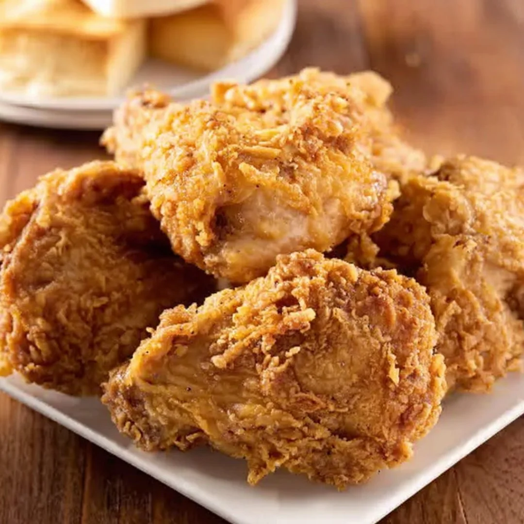 Crispy and juicy Oven Fried Chicken on a plate, garnished with herbs.